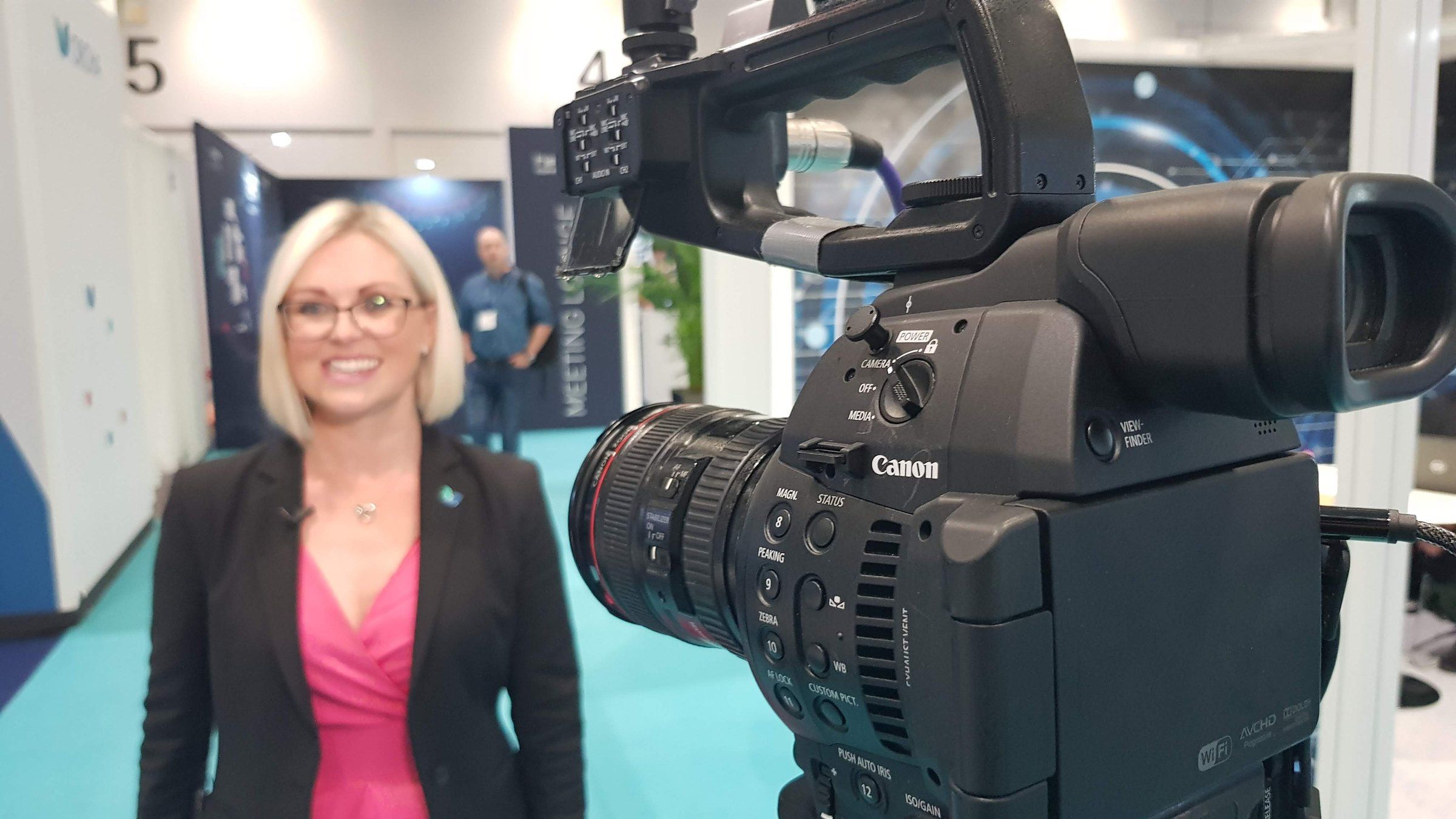 An exhibitor smiling during a filmed interview on her stand