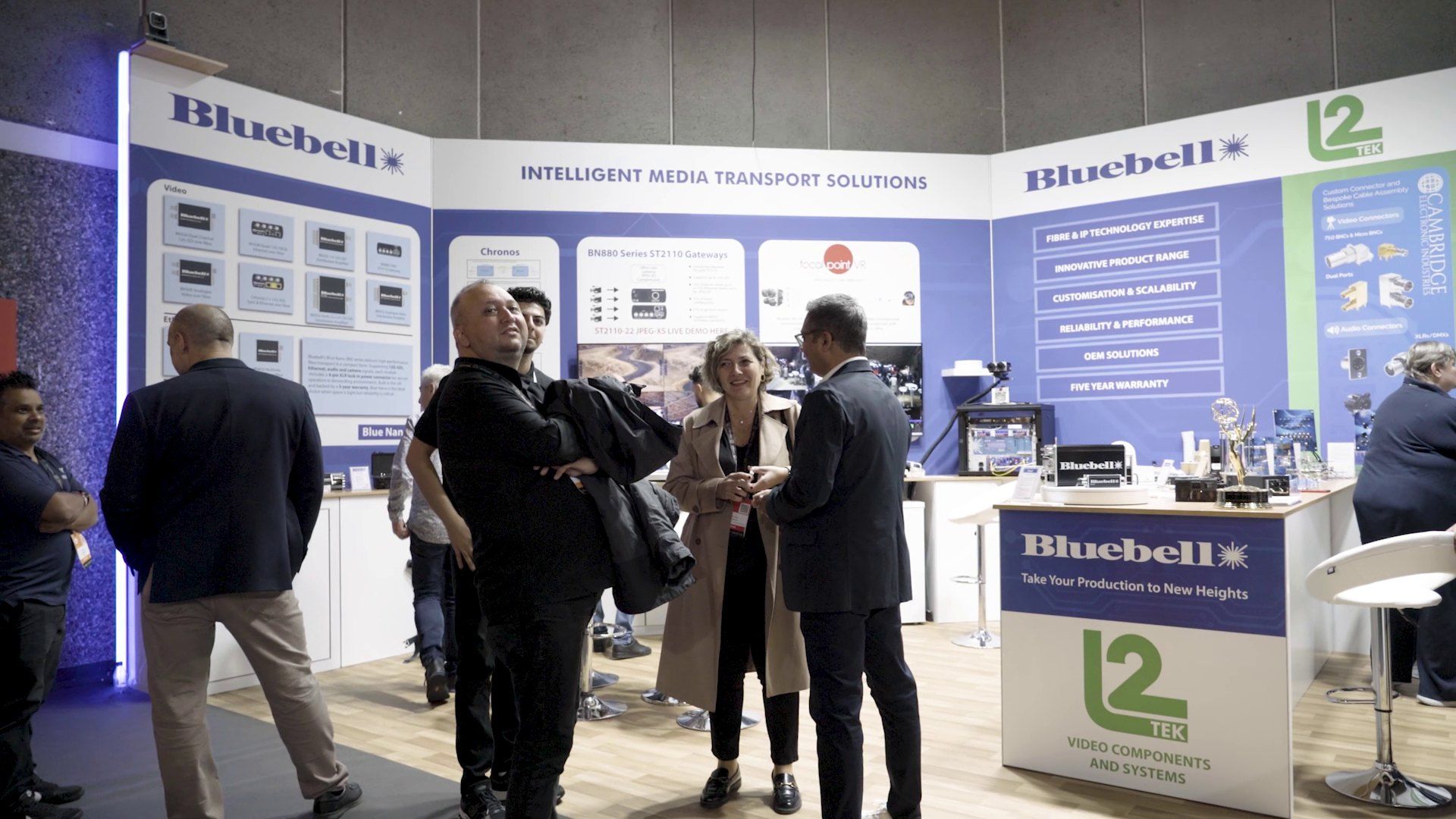 Visitors talking with staff on the Bluebell Opticom stand at IBC