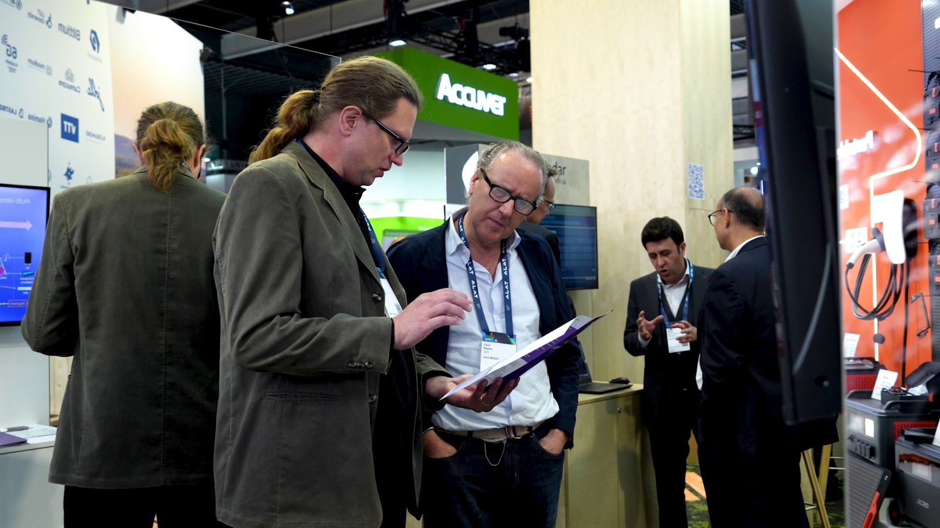 Visitors reading material with staff on the Creanord stand at Mobile World Congress